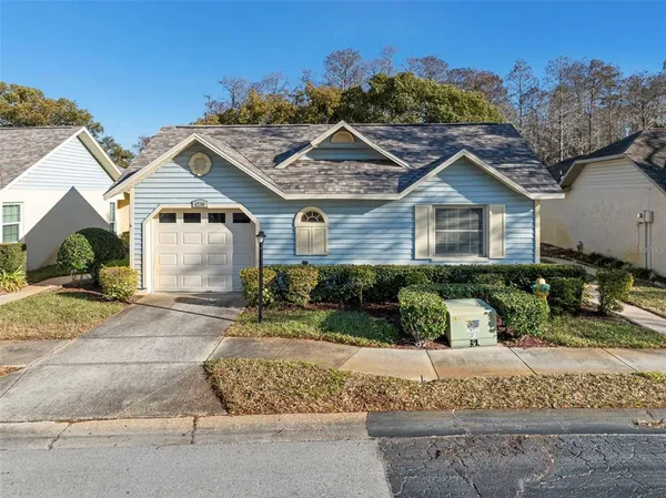a front view of a house with a yard and potted plants