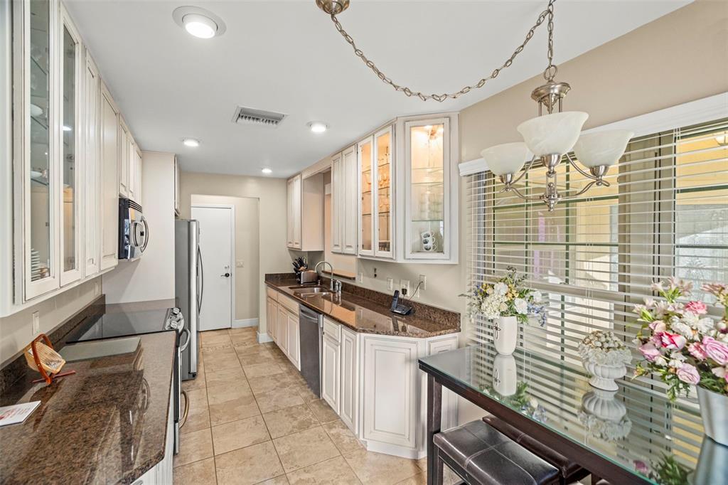 4730 Sheffield Drive New Port Richey, FL 34655 - Photo 14 of 53 a kitchen with granite countertop a stove a sink a refrigerator and cabinets
