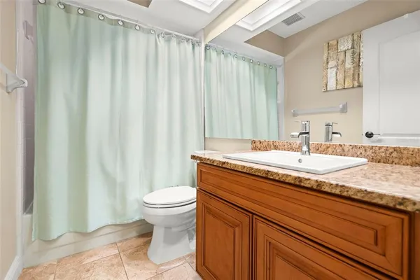 a bathroom with a granite countertop toilet a sink and bathtub