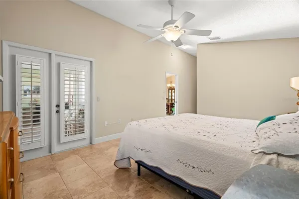 a spacious bedroom with a bed and a chandelier