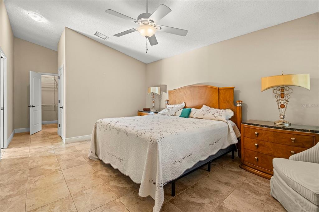 4730 Sheffield Drive New Port Richey, FL 34655 - Photo 22 of 53 a spacious bedroom with a bed and a chandelier