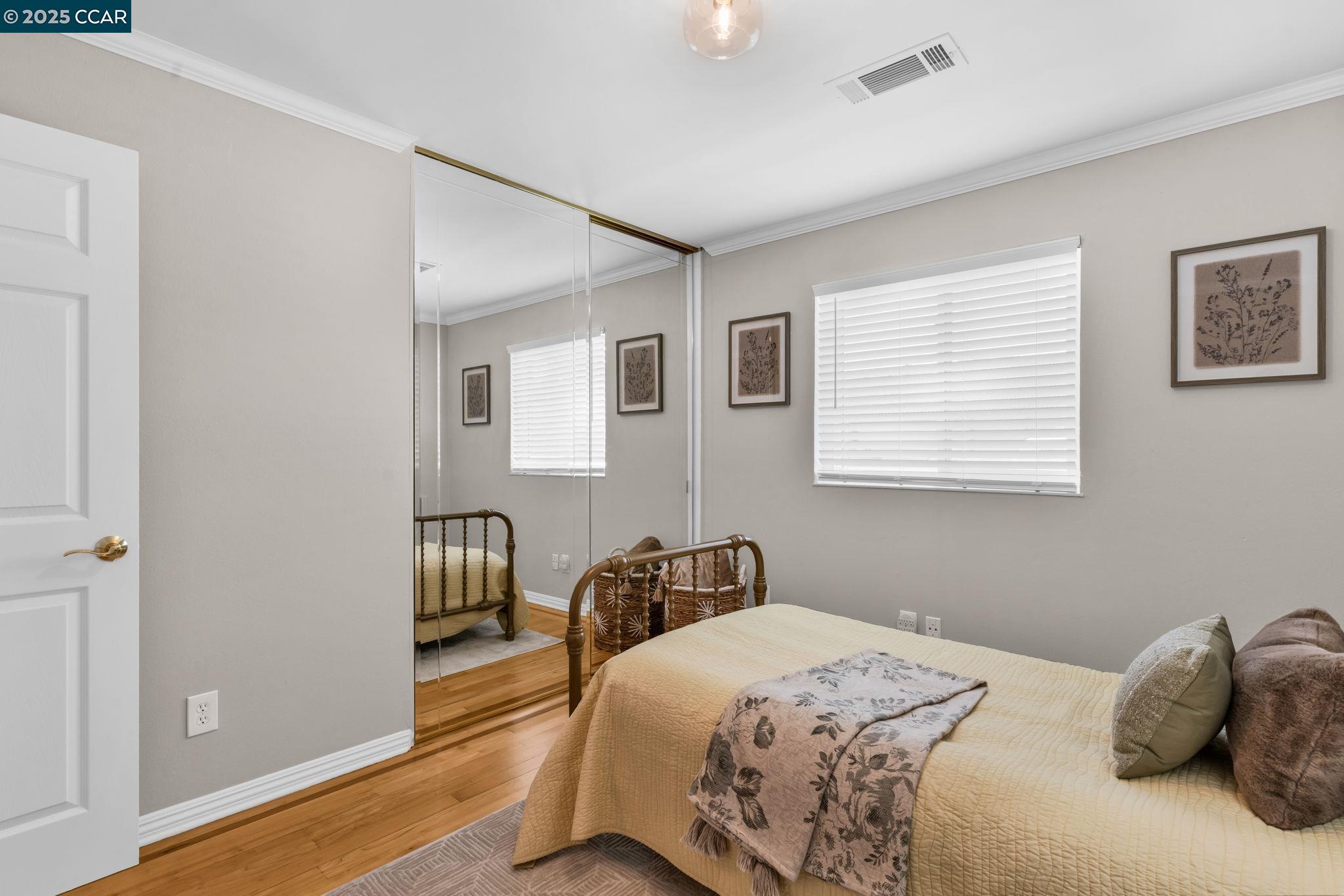 4380 St Charles Place Concord, CA 94521 - Photo 29 of 54 a bedroom with a bed and wooden floor