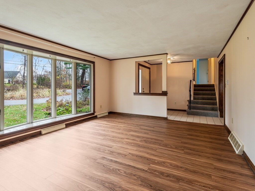 21 Hutchinson Road Sutton, MA 01590 - Photo 6 of 41 a view of an empty room with wooden floor and a window