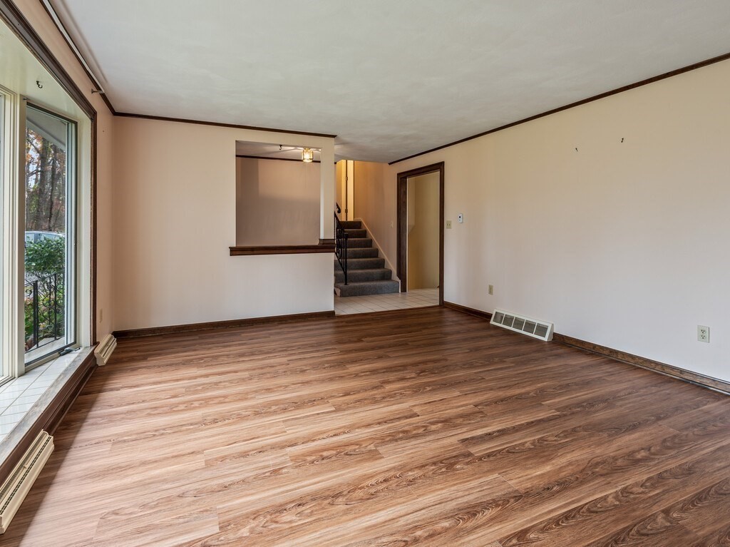 21 Hutchinson Road Sutton, MA 01590 - Photo 7 of 41 a view of an empty room with wooden floor and stairs