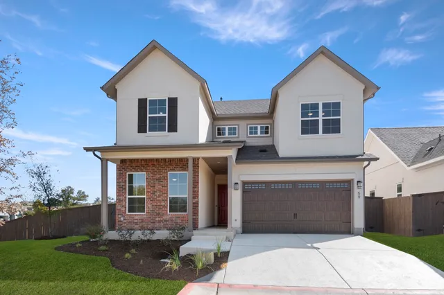 a front view of a house with a garden and garage