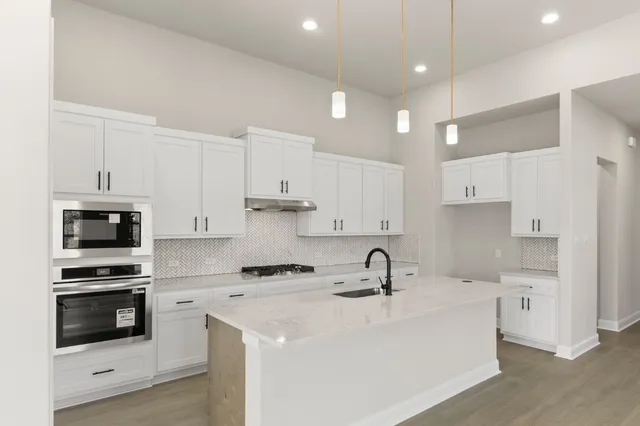 a kitchen with kitchen island a sink stainless steel appliances and cabinets