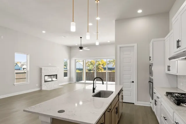 a kitchen with stainless steel appliances granite countertop a sink a stove and a refrigerator