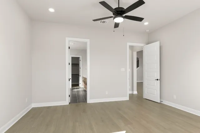 an empty room with fan and entrance
