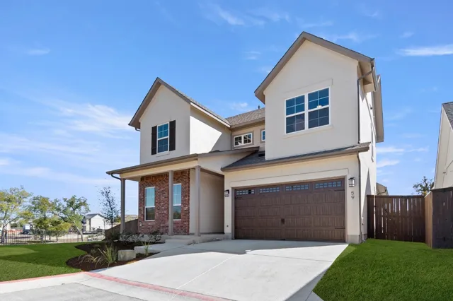 a front view of a house with a garden and garage
