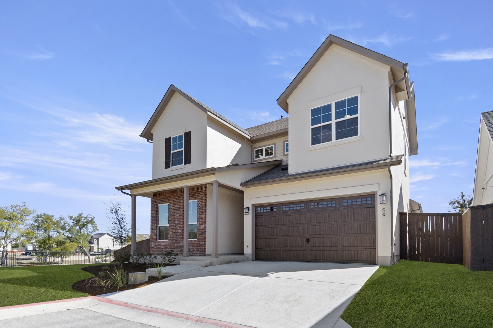 601 C-Bar Ranch Trail, Unit 59 Cedar Park, TX 78613 - Photo 2 of 34 View of front of property featuring stucco siding, a garage, concrete driveway, brick siding, and a porch