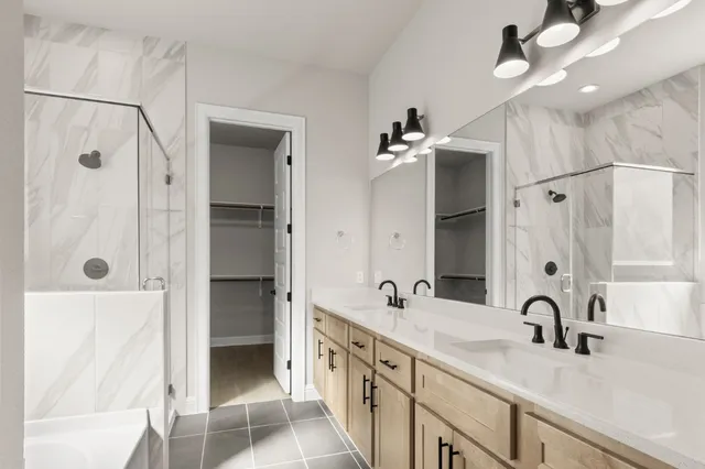 a bathroom with a double vanity sink mirror and shower