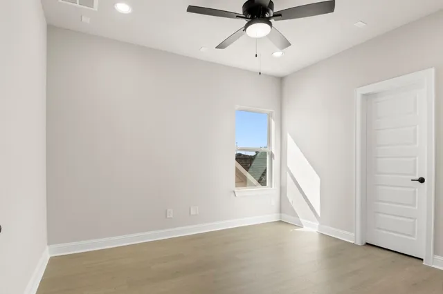an empty room with a ceiling fan and carpet