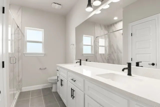 a bathroom with a double vanity sink mirror and toilet