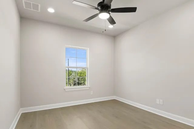 an empty room with a window and a fan