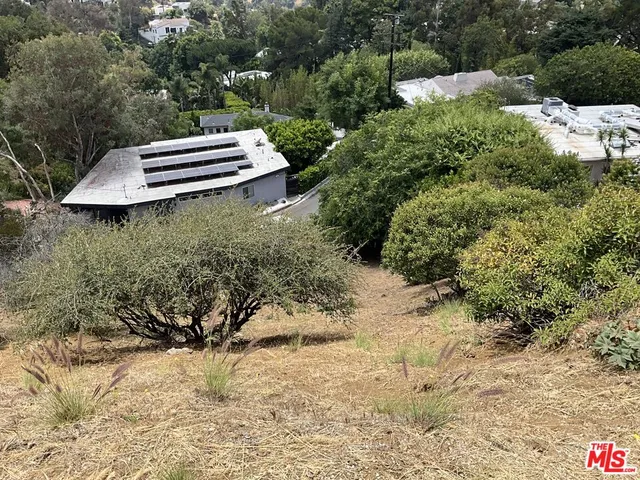 a view of a yard with wooden fence