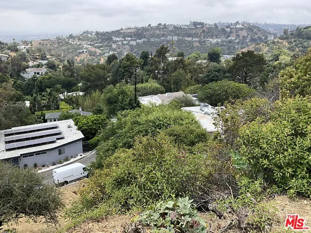 an aerial view of a house with a yard and mountain view in back