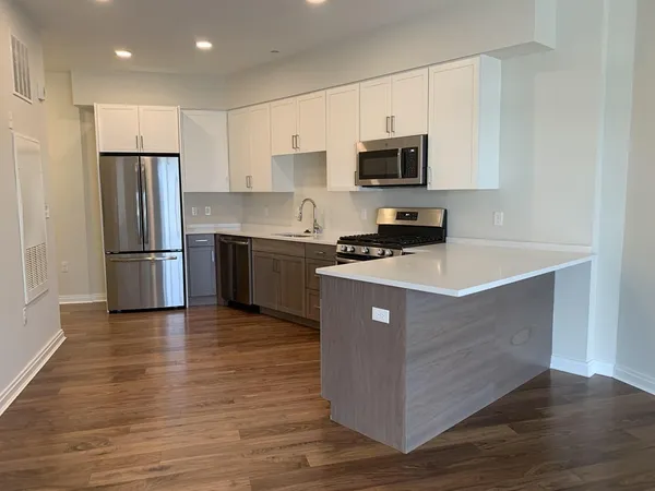 a kitchen with stainless steel appliances granite countertop a refrigerator stove a sink and a microwave