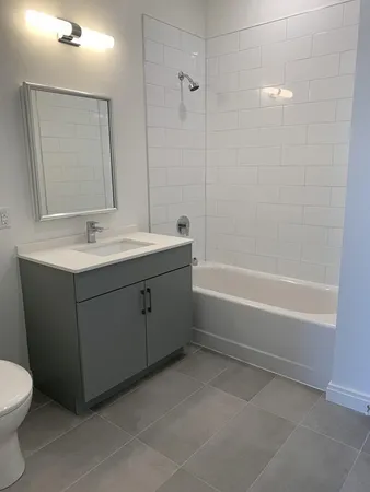 a bathroom with a tub sink toilet and mirror