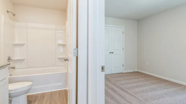 a bathroom with a granite countertop sink a toilet and shower