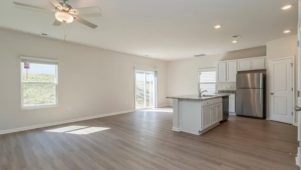 a kitchen with stainless steel appliances granite countertop a refrigerator a sink dishwasher a stove and white countertops with wooden floor