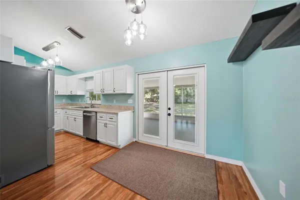a kitchen with stainless steel appliances granite countertop a stove a sink and a microwave