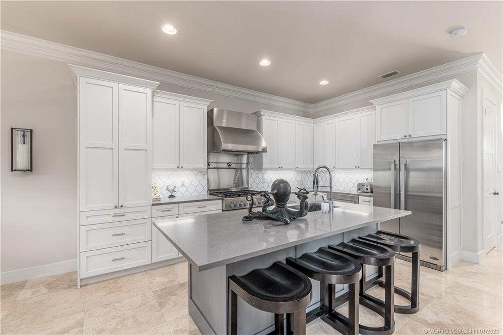 213 Coconut Avenue Stuart, FL 34996 - Photo 5 of 27 a kitchen with refrigerator and cabinets