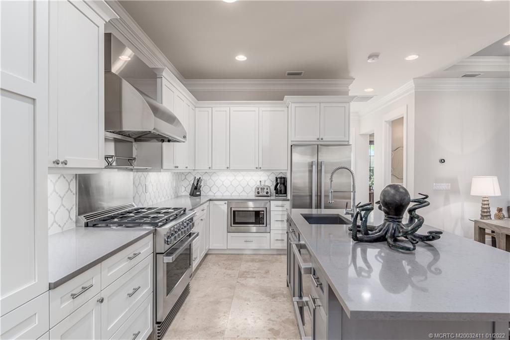 213 Coconut Avenue Stuart, FL 34996 - Photo 8 of 27 a kitchen with white cabinets and appliances