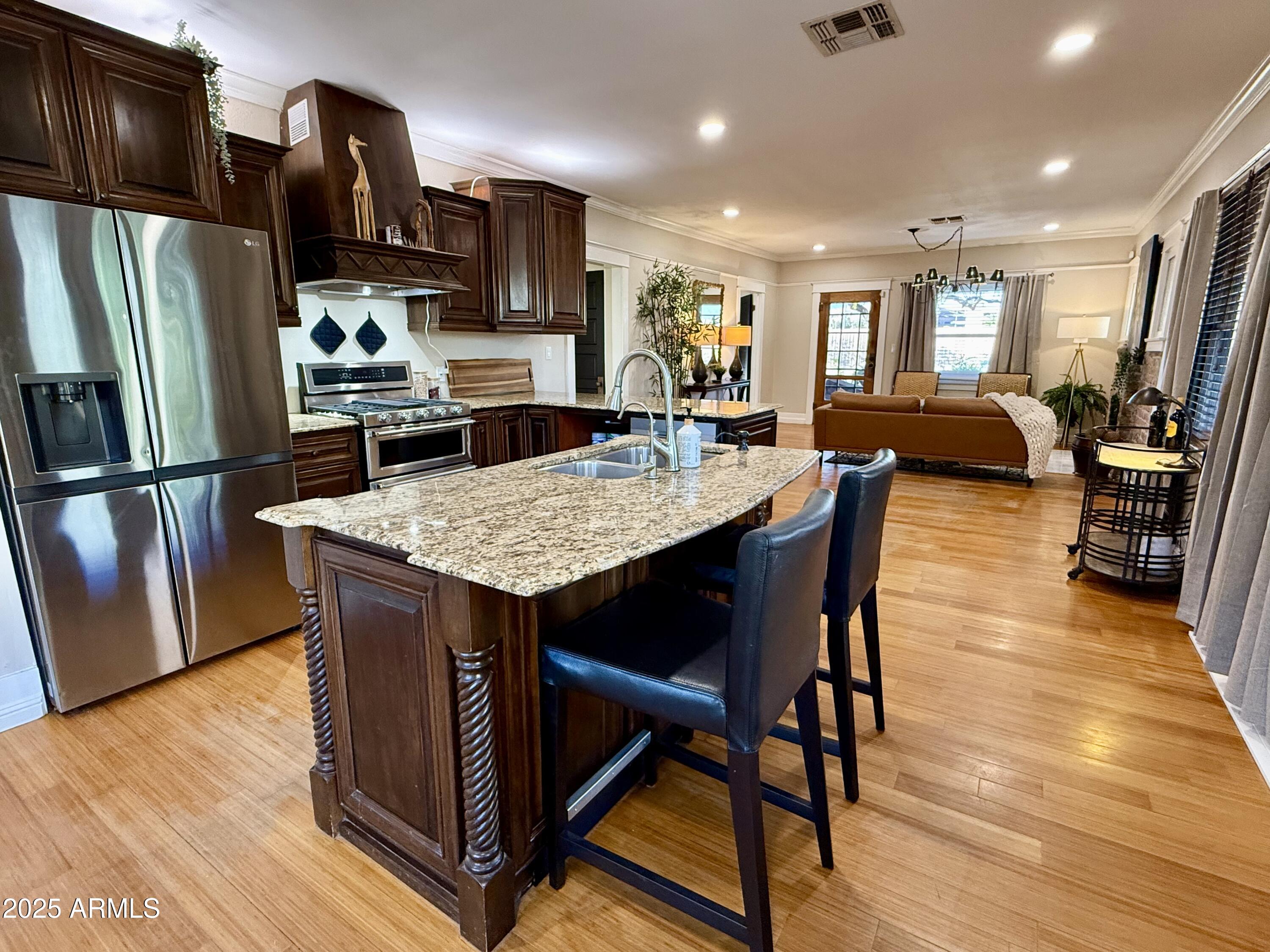 723 East Moreland Street Phoenix, AZ 85006 - Photo 10 of 25 a kitchen with stainless steel appliances granite countertop a table chairs refrigerator and a sink