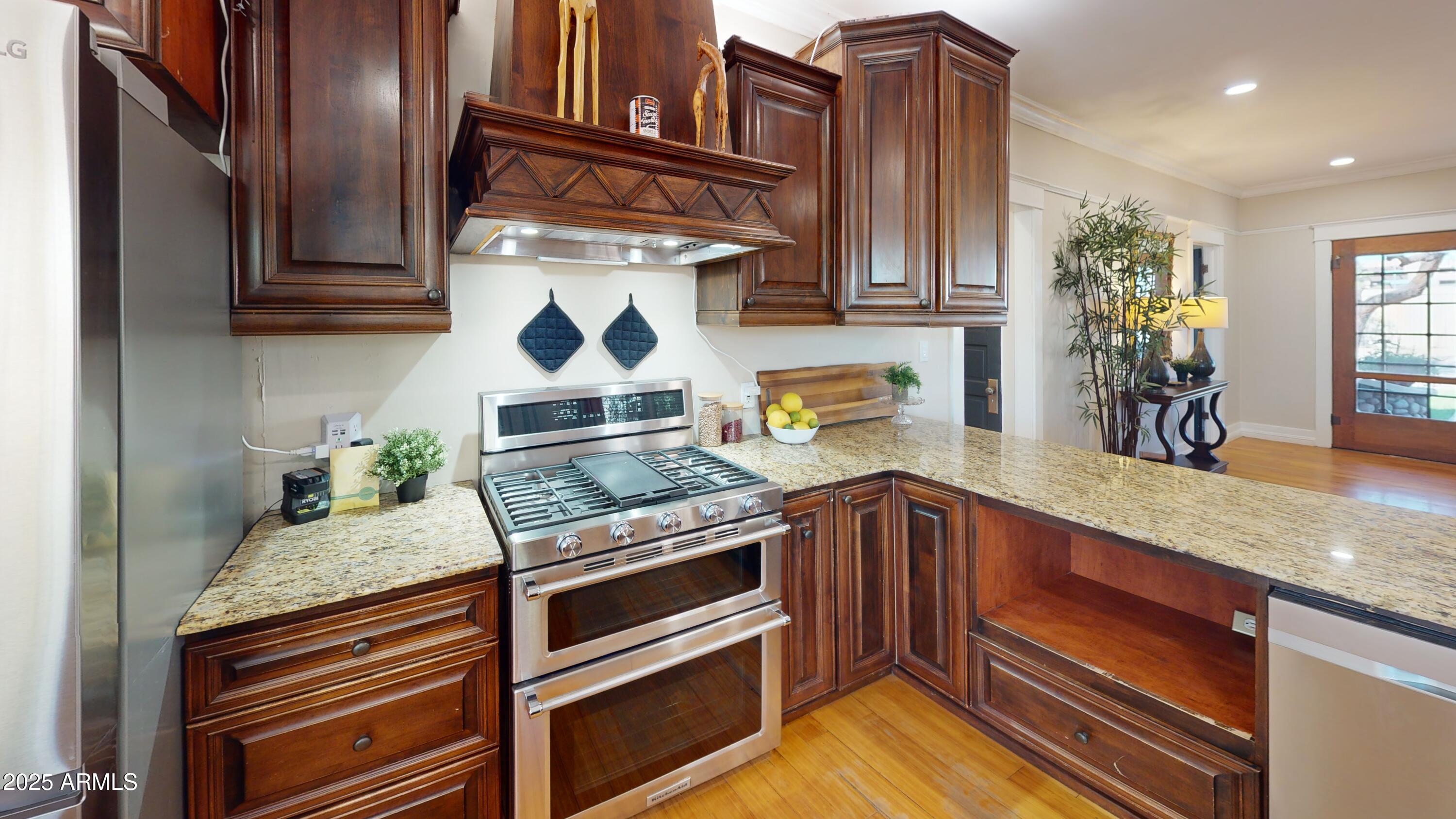 723 East Moreland Street Phoenix, AZ 85006 - Photo 11 of 25 a kitchen with stainless steel appliances granite countertop a stove and cabinets