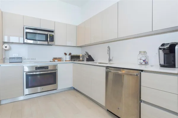 a kitchen with white cabinets and stainless steel appliances