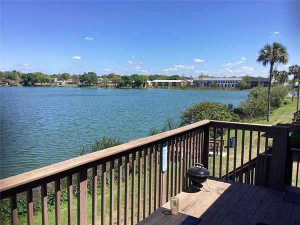 a balcony with wooden floor and lake view