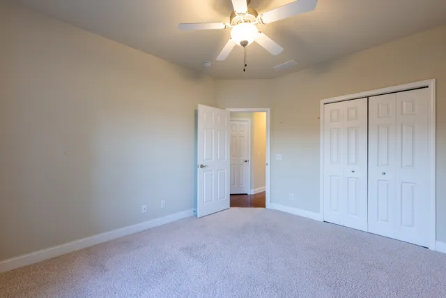 a view of an empty room and a chandelier fan