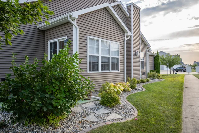a view of a house with a yard and potted plants