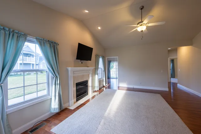 a view of a livingroom with a fireplace window and wooden floor