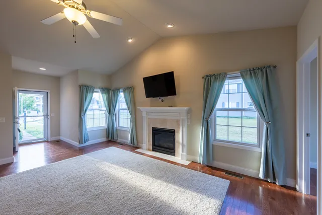 wooden floor fireplace and windows in an empty room