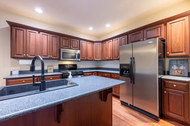 a kitchen with granite countertop a refrigerator stove and sink