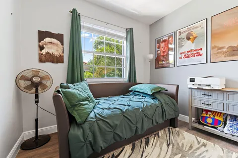 a bedroom with a bed a painting on the wall and a window