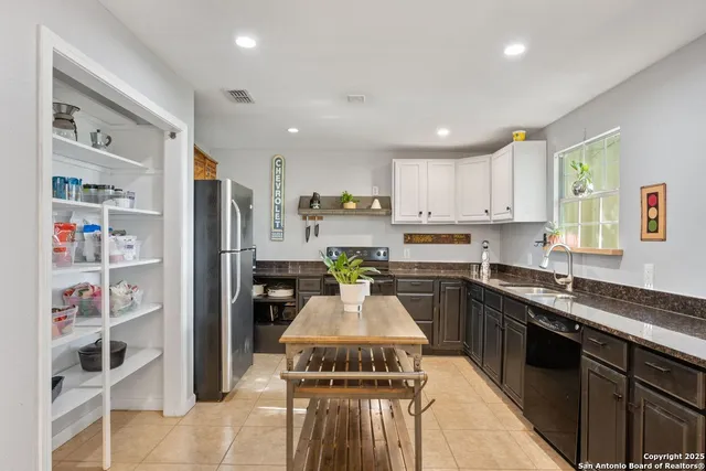 a kitchen with a refrigerator sink and cabinets