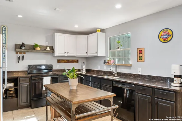 a kitchen with a sink a stove and cabinets