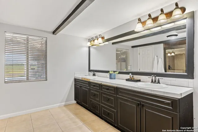 a bathroom with a double vanity sink and a mirror