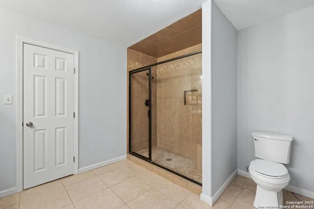 a bathroom with a toilet and a shower