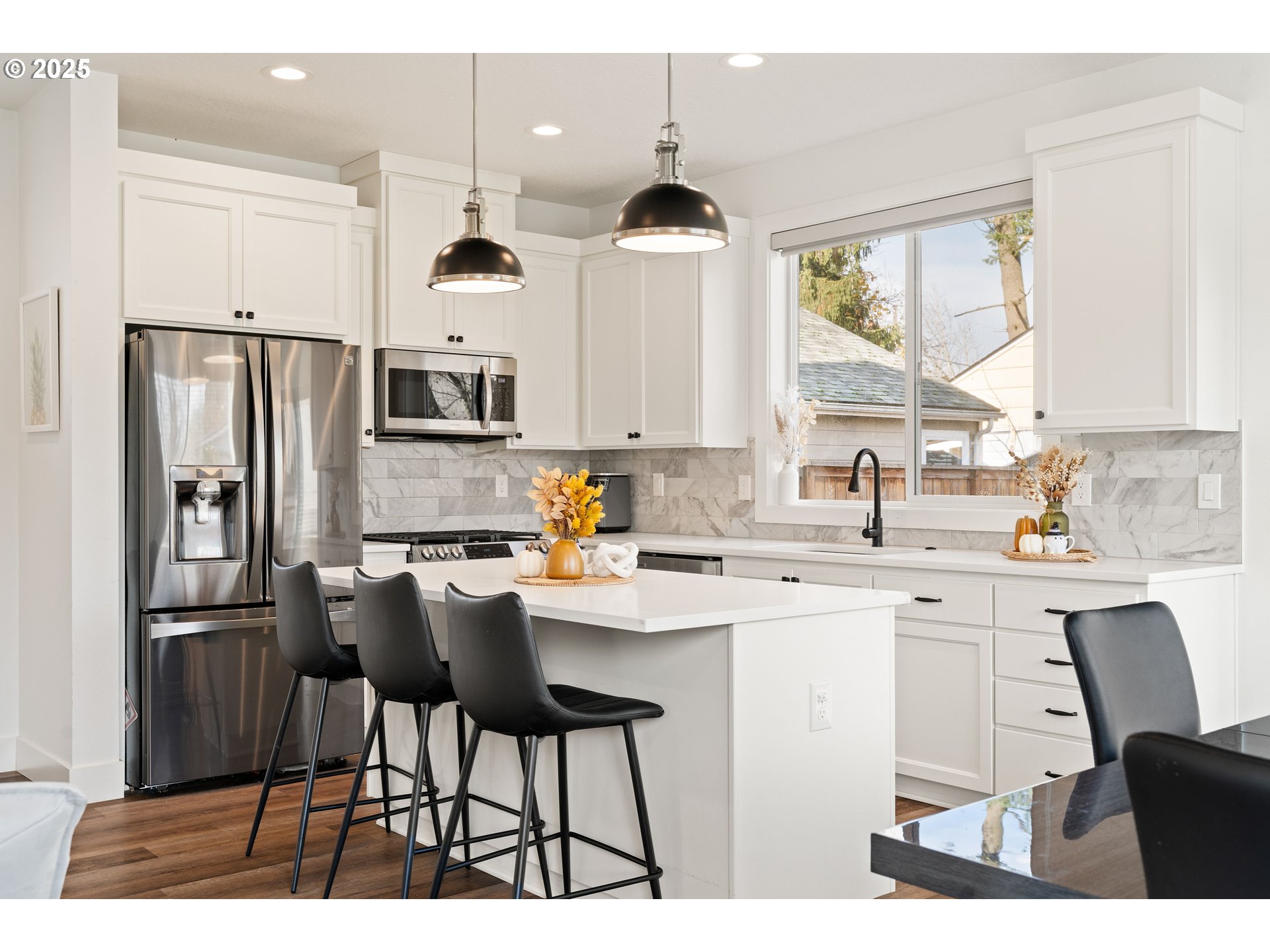 6421 Southeast Cooper Street Portland, OR 97206 - Photo 15 of 44 a kitchen with stainless steel appliances kitchen island a table chairs sink refrigerator and cabinets