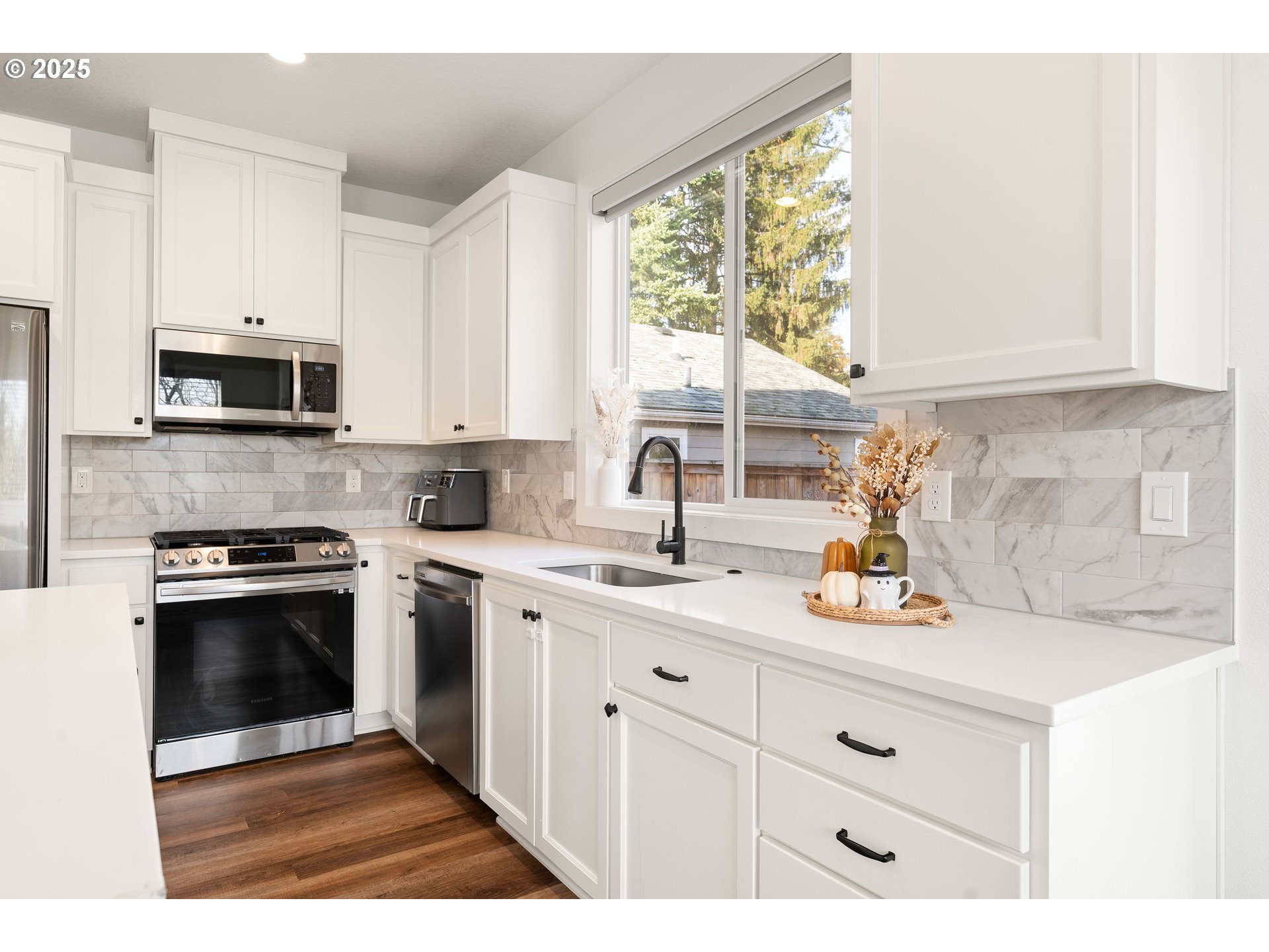 6421 Southeast Cooper Street Portland, OR 97206 - Photo 17 of 44 a kitchen with stainless steel appliances white cabinets a sink and a stove