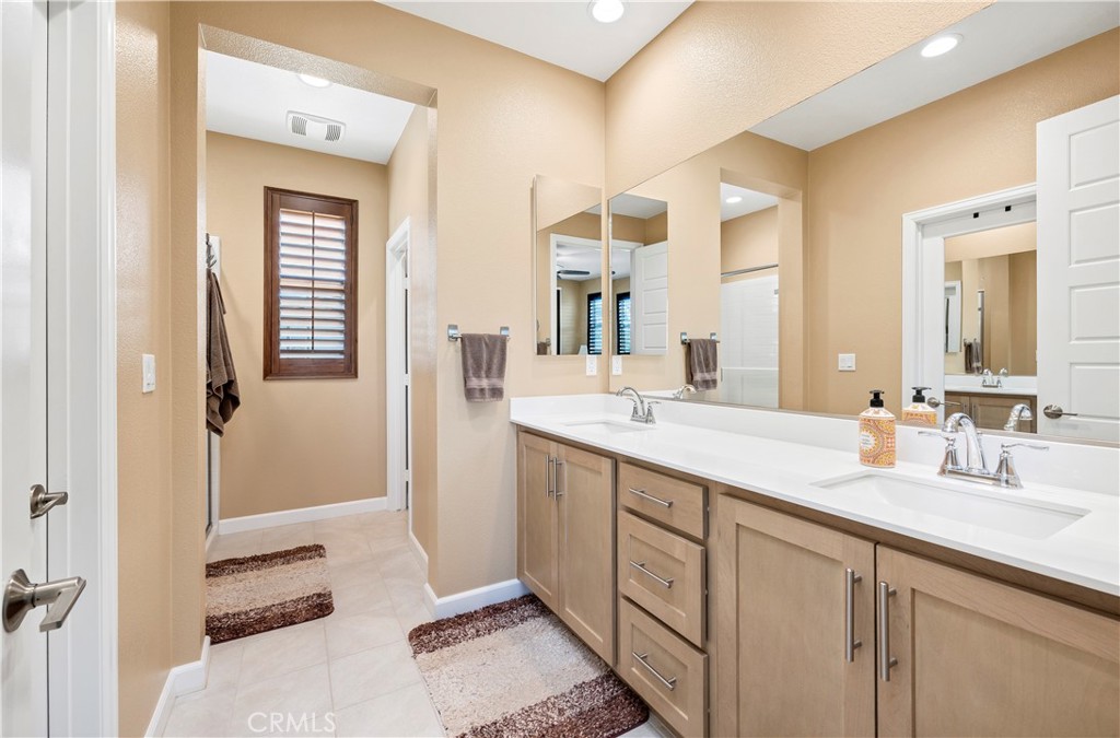 39320 Brunello Way Temecula, CA 92591 - Photo 20 of 52 a spacious bathroom with a double vanity sink a mirror and a shower