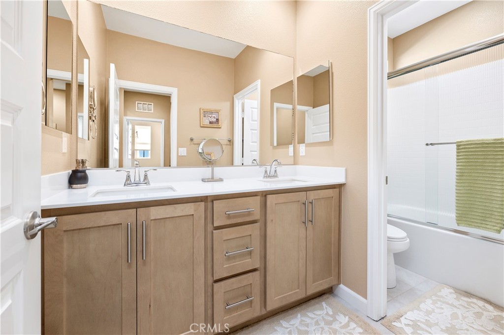 39320 Brunello Way Temecula, CA 92591 - Photo 26 of 52 a bathroom with a double vanity sink mirror and toilet