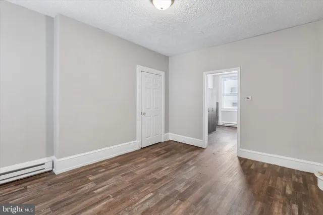 a view of an empty room with wooden floor