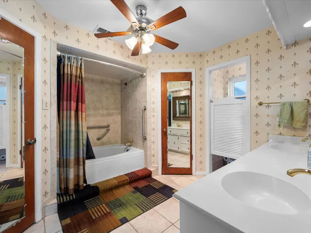 a spacious bathroom with a double vanity sink mirror and bathtub