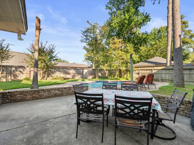 an aerial view of a house with swimming pool and large trees