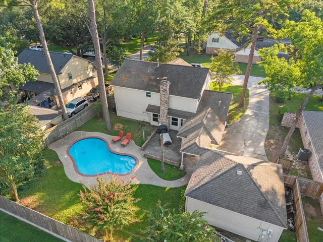 an aerial view of residential houses with outdoor space and trees