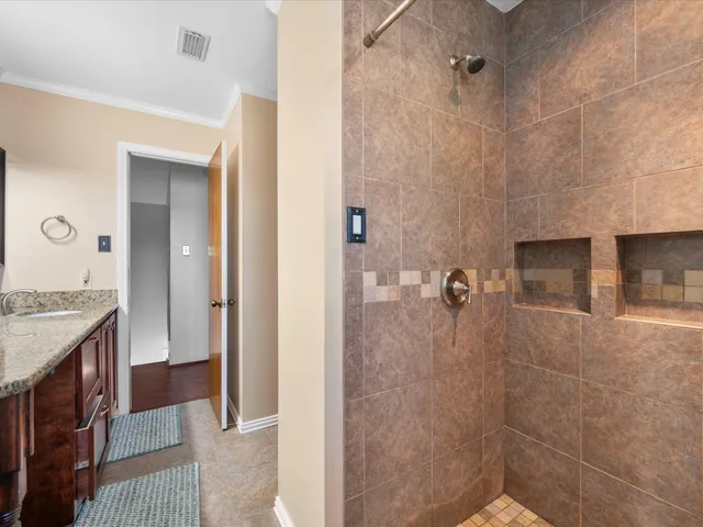 a bathroom with a granite countertop shower a sink and a mirror
